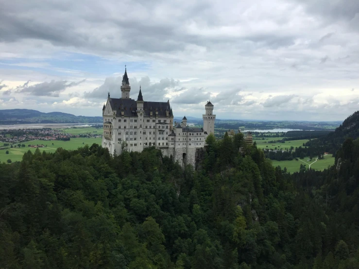 a castle on top of a lush green forest