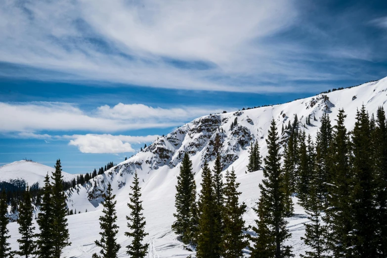 the snow covered mountain on the side of the road