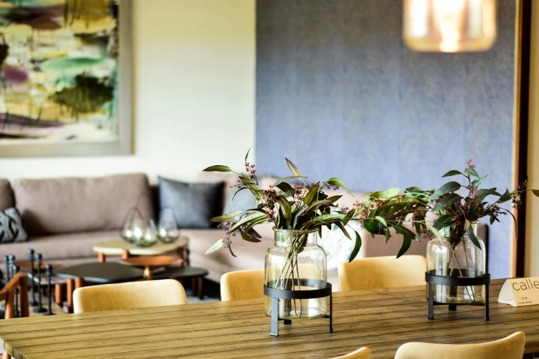 a wooden table with chairs and vases on it