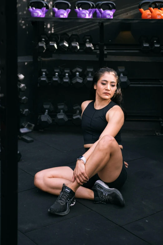 a woman squatting on the ground at a boxing gym