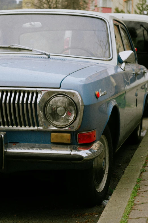 a blue car is sitting near a curb