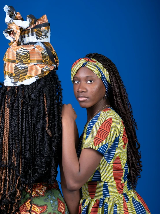 two beautiful black women holding onto hats that they were made from beads