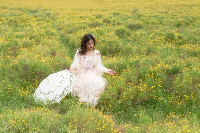 a woman wearing a wedding dress, sitting in tall grass