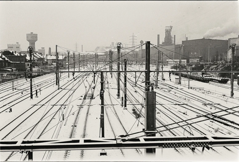 railroad tracks with snow and trains and buildings