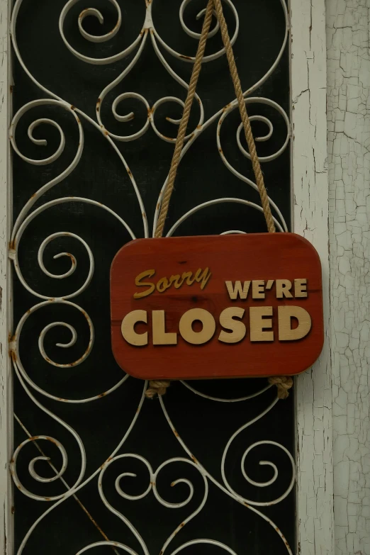 a close up of a sign on a door with a wrought iron frame