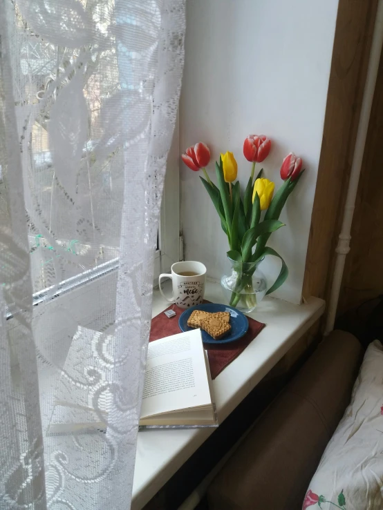 a table topped with a book and flowers