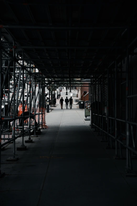 people walking through a dark structure with scaffolding