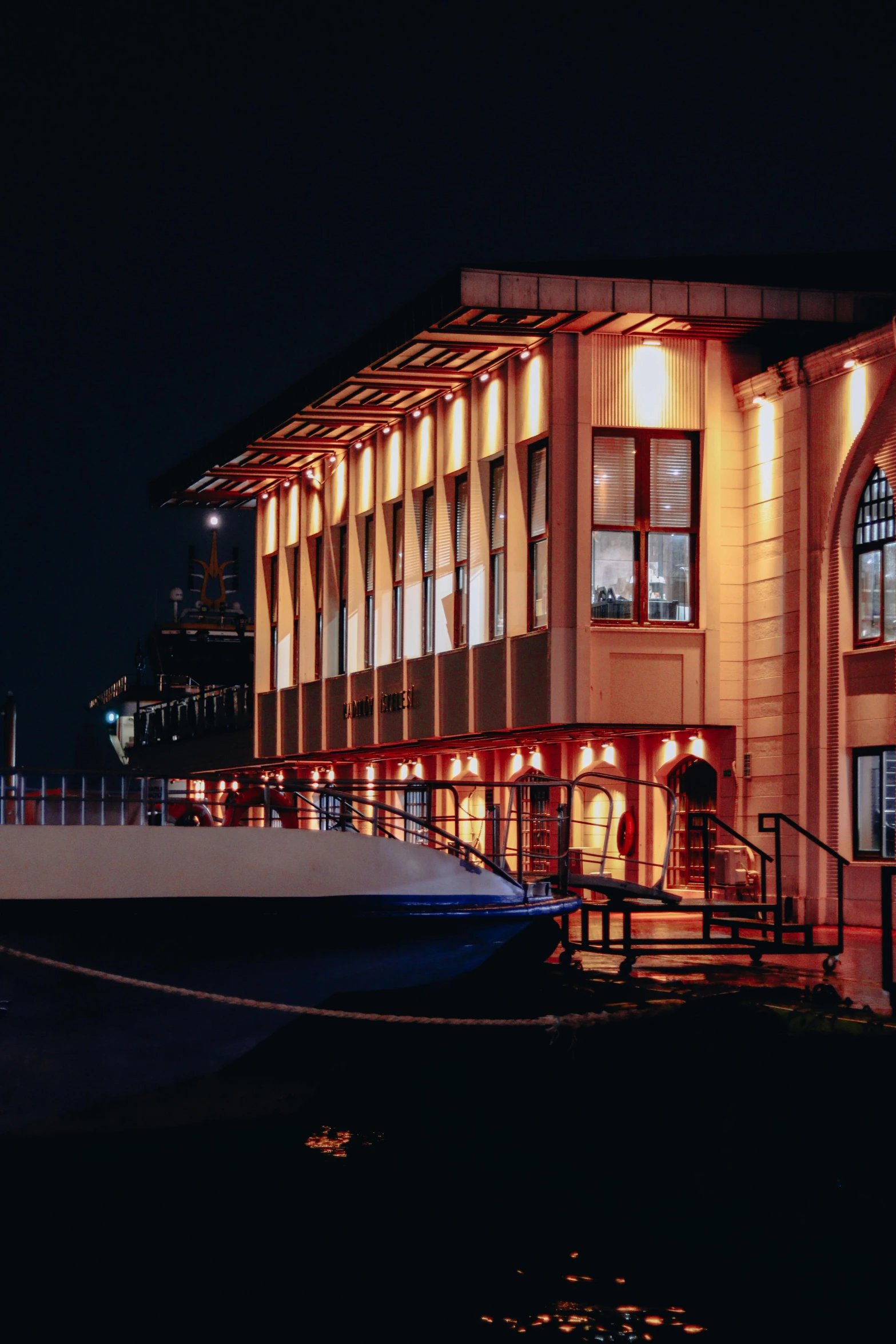 the light shows bright orange as people walk out of the building at night