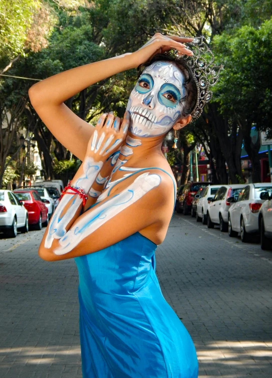 a woman in a dress with skeleton painted on her face and chest poses