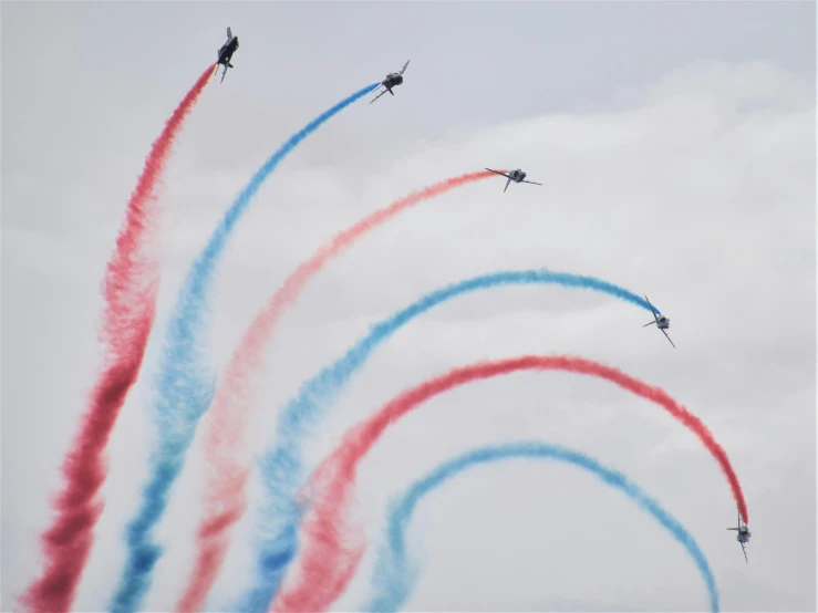 airplanes in the sky with colored smoke trails