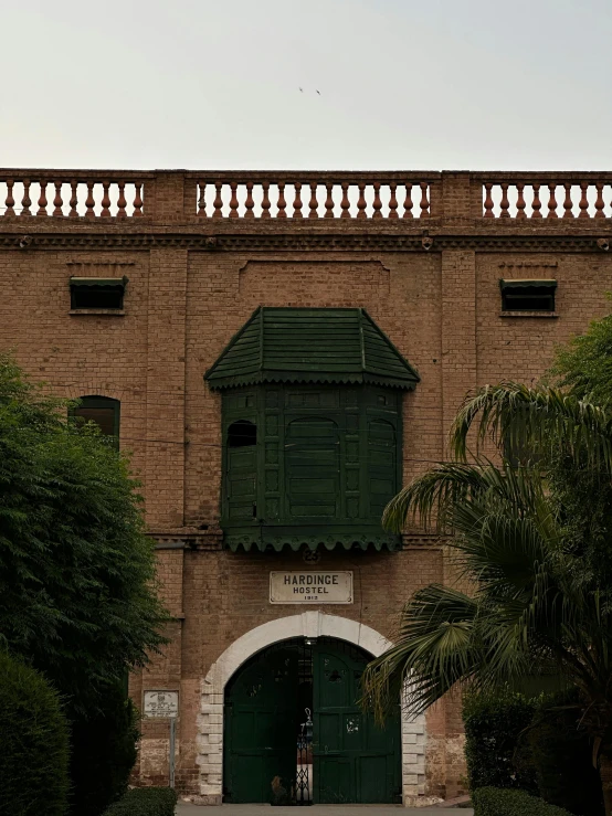 a brown building that has a green door and green shutters