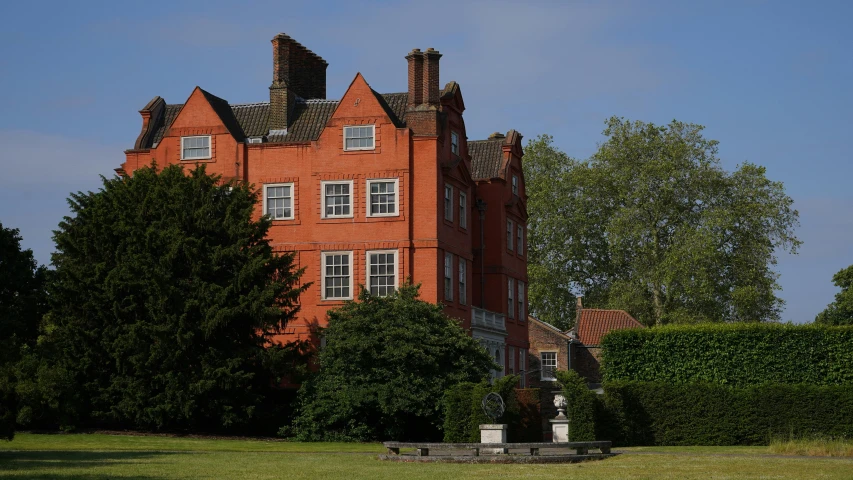 large red brick mansion in residential area with hedges