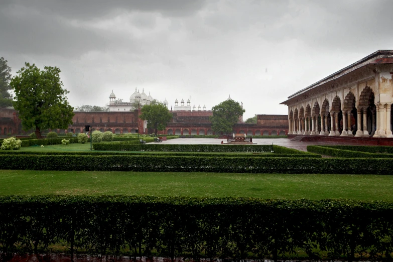 a building surrounded by an enclosed garden with green grass