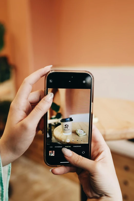 the woman is holding her smartphone taking a po