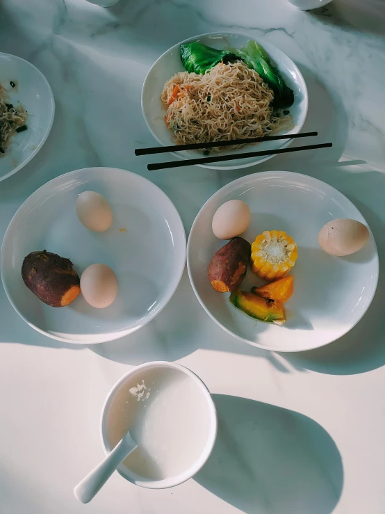 two bowls of food sit on a counter with chop sticks