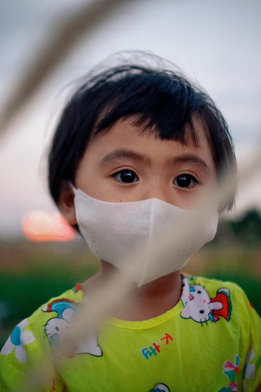 an asian boy with a surgical mask on