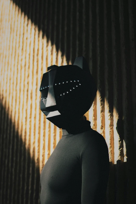 a person with an animal mask standing next to corrugated structure