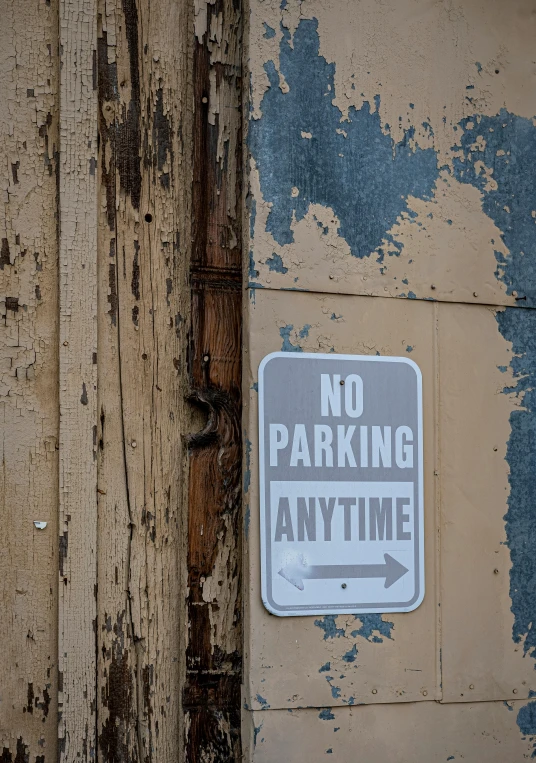 no parking anytime sign on door with painted wood