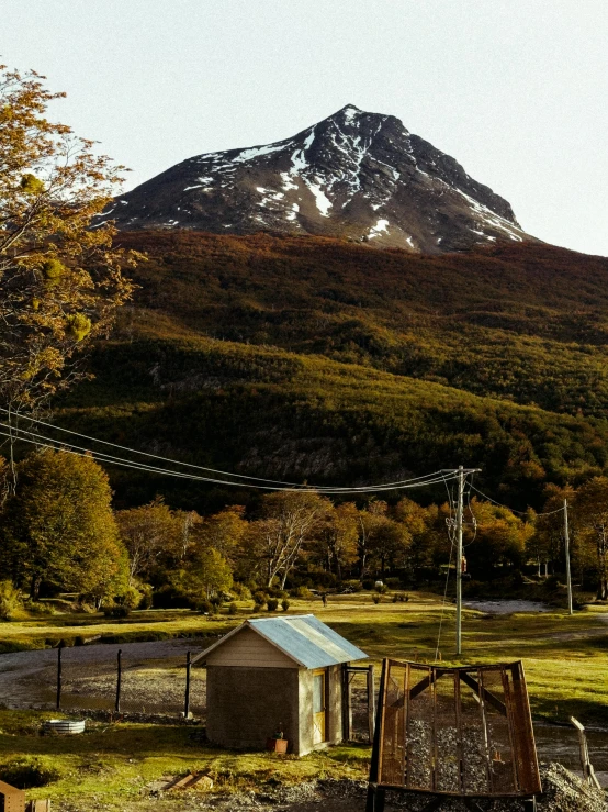 a mountain and an old shack in front of it