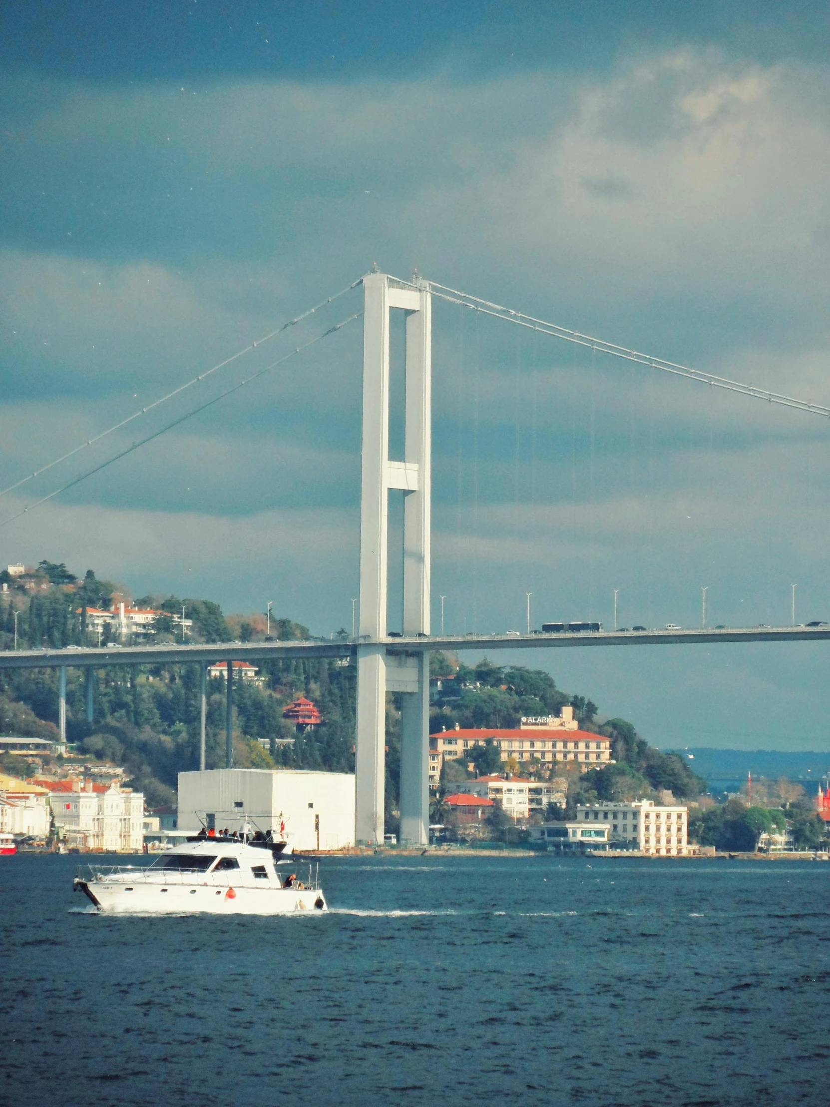 there is a boat sailing on the water near the bridge