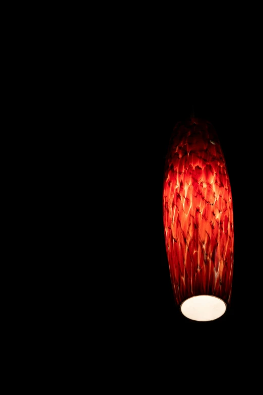 a red hanging lamp shines in the dark