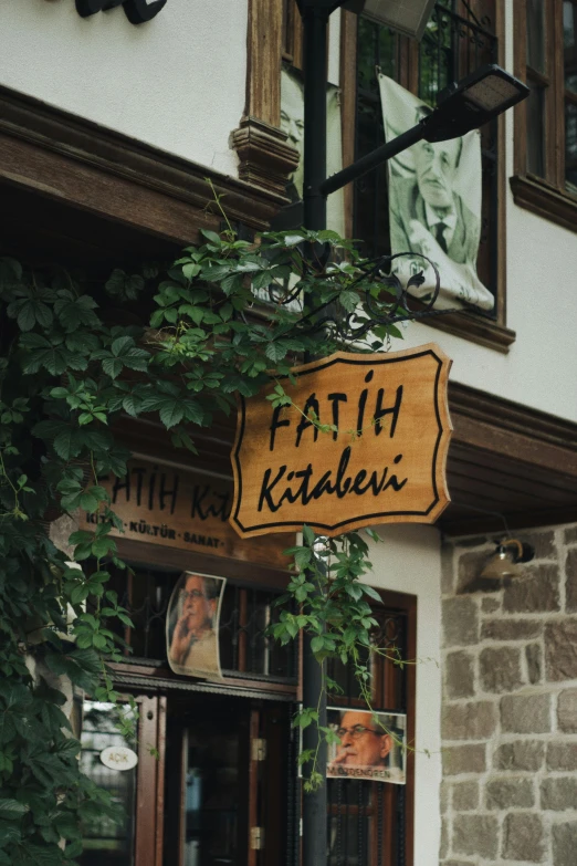 a sign that reads faith kastabini hanging off the side of a building