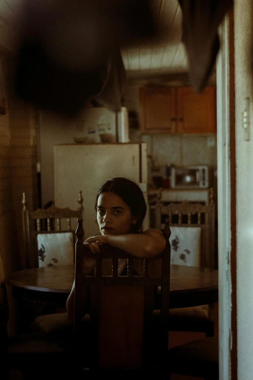 a child sitting at a table and looking over