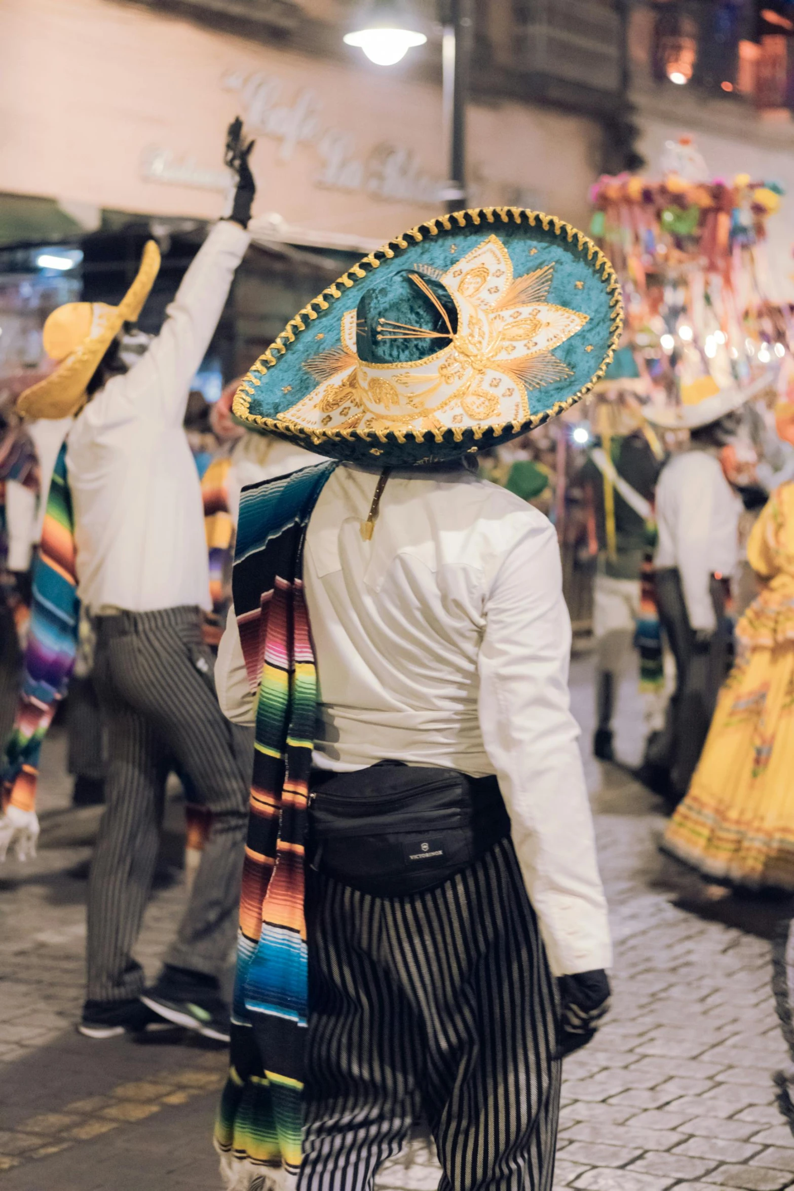 a man with a sombrero walking down the street