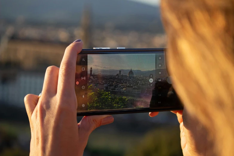 a person holding up a cellphone to take a po