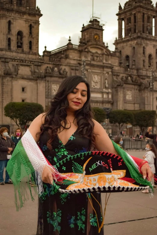 the woman in the dress is holding a mexican sign