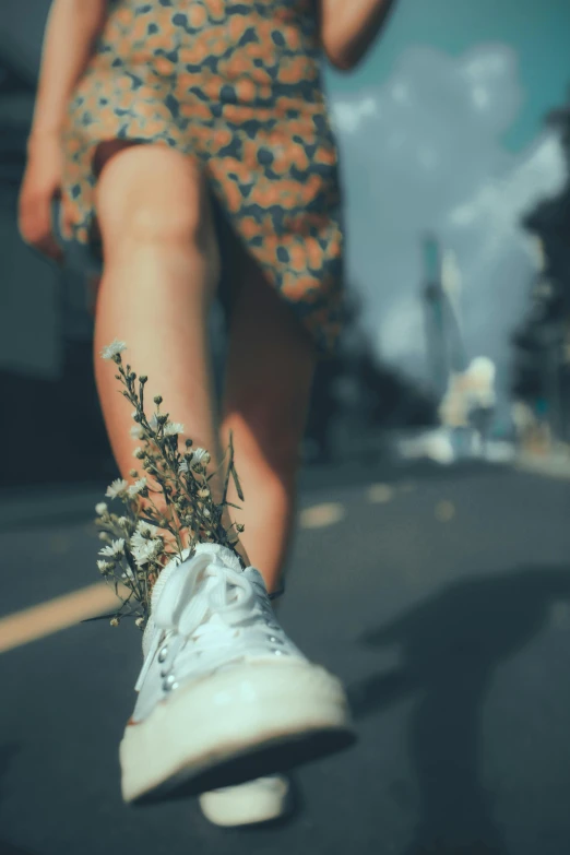 a person with their legs wrapped around a shoe and flowers