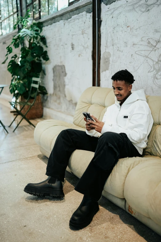 man sitting on couch using his cell phone