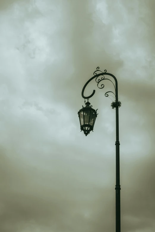 a street light sitting under a cloudy sky