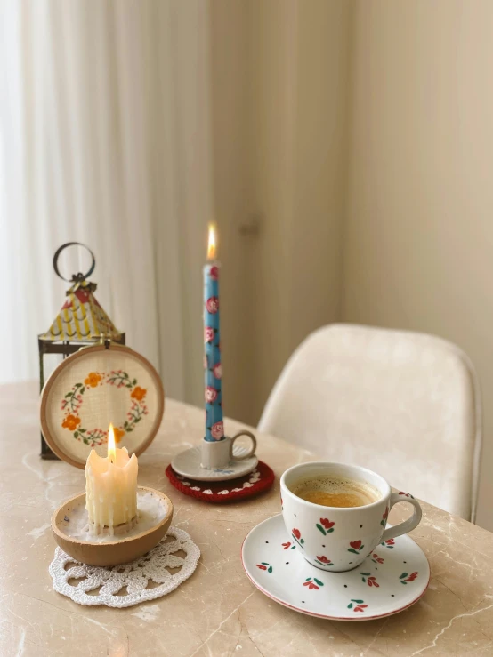 a candle and a plate with a cup on it