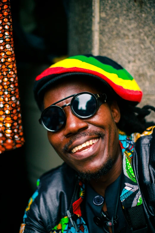 a man in glasses and a rasp striped hat smiling