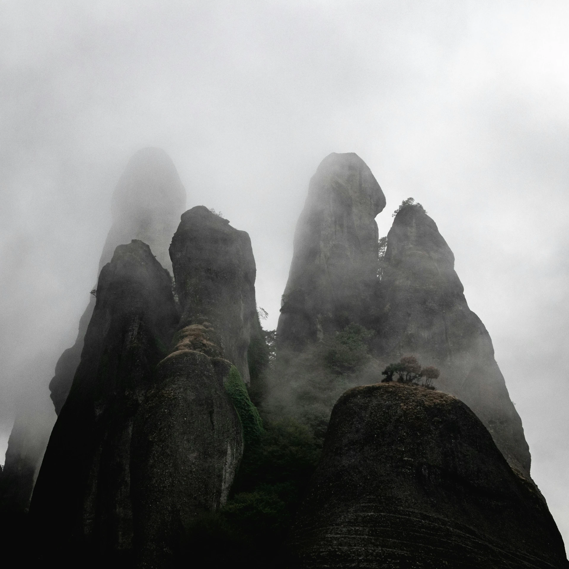 a group of rock formations surrounded by mist