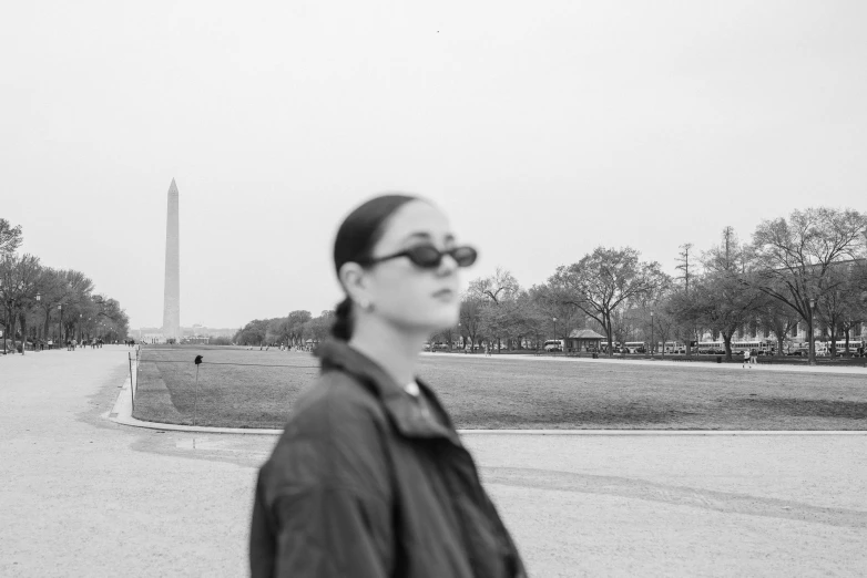 a black and white po of someone with shades on in front of the washington monument