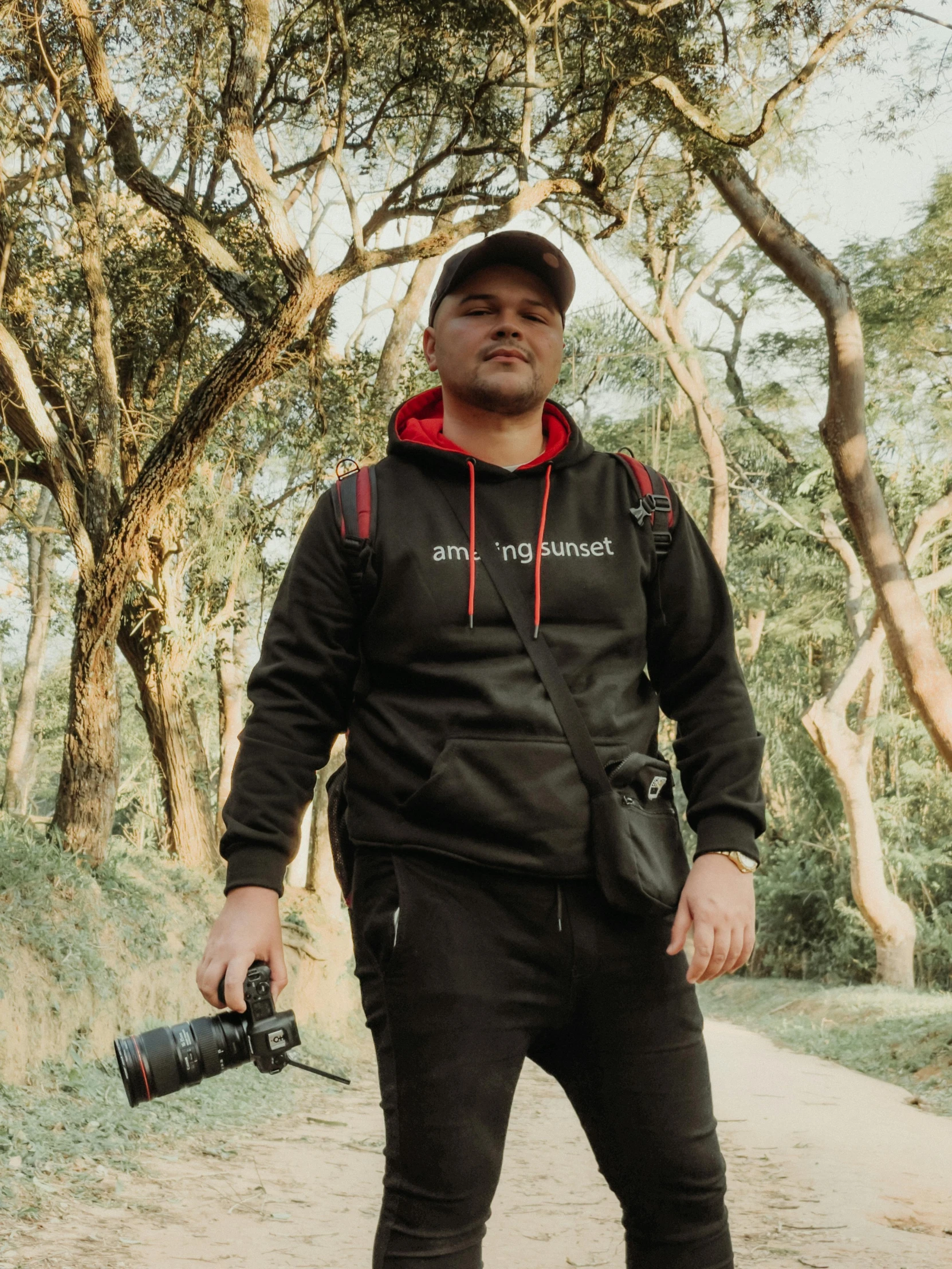 a man in a hat and hoodie holding a camera