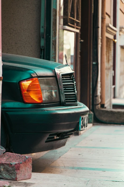 the back end of a blue car parked on a street