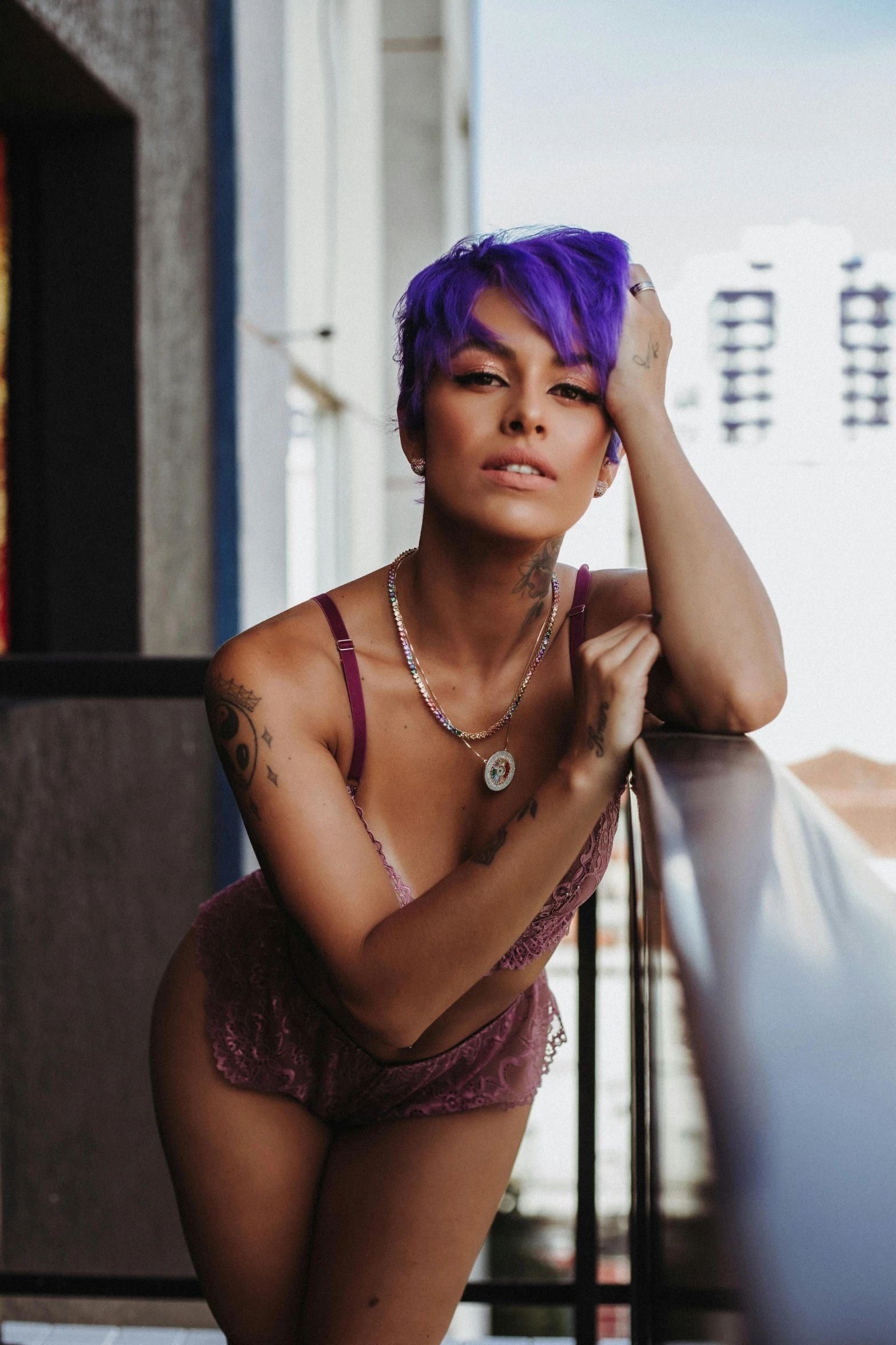 a woman with purple hair wearing underwear posing for the camera