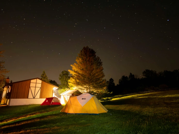 two tents sitting on top of a lush green field