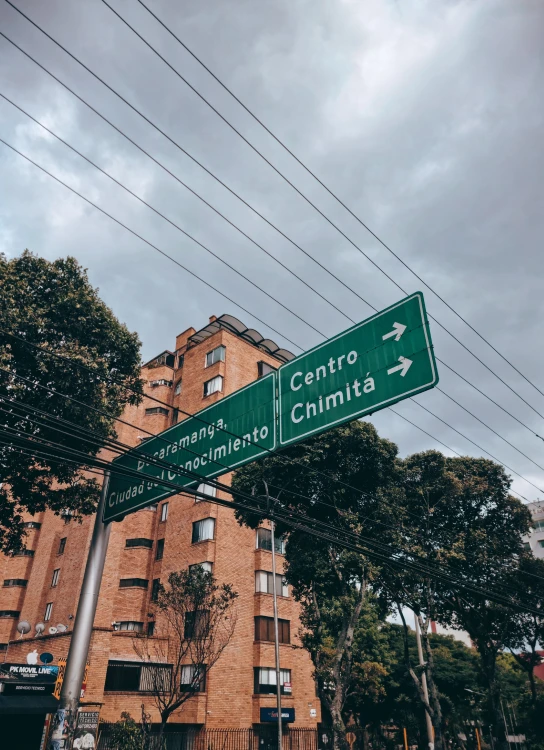 there are two green street signs in front of a building