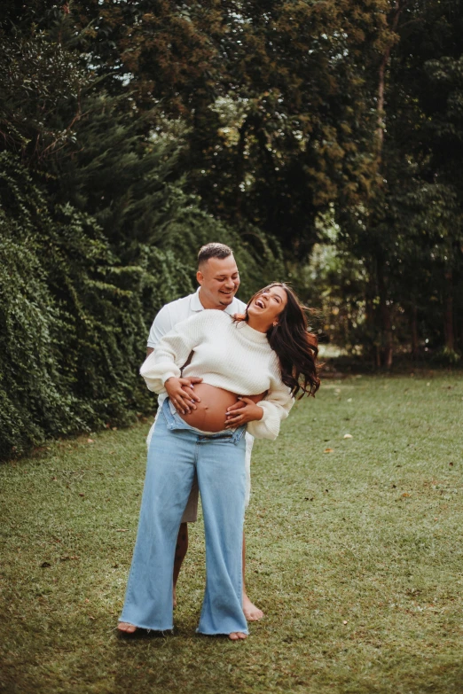 a man holding onto a woman standing in the grass