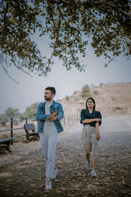 two people walking down a tree lined road