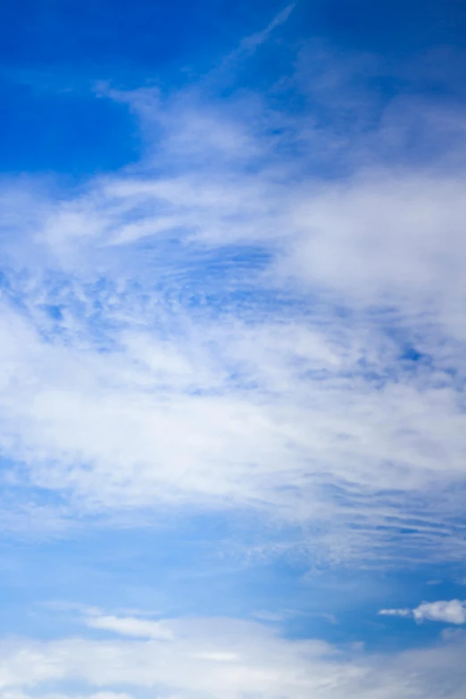 a airplane flying through a blue sky with white clouds