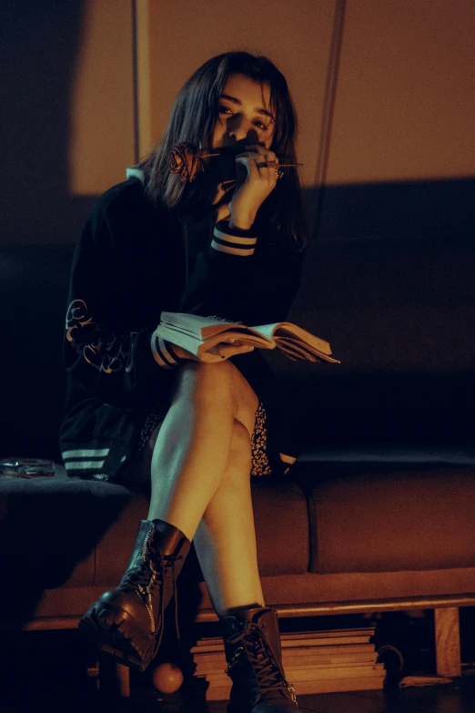 a woman with long hair and boots talking on a cell phone