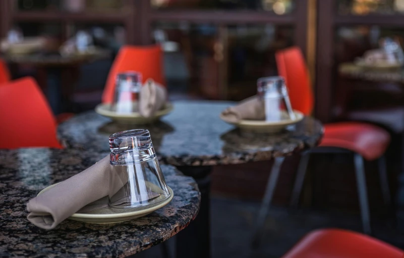 a small table is surrounded by red chairs