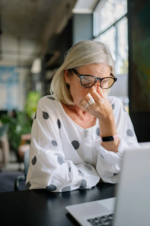 woman with glasses using a laptop computer at a restaurant