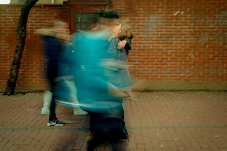 a blurred image of people walking by on a brick sidewalk