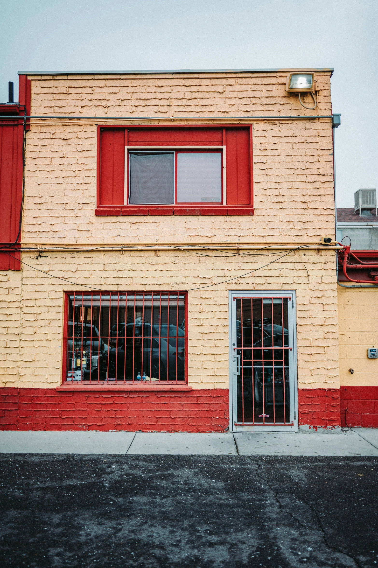 an empty brick building with two red windows